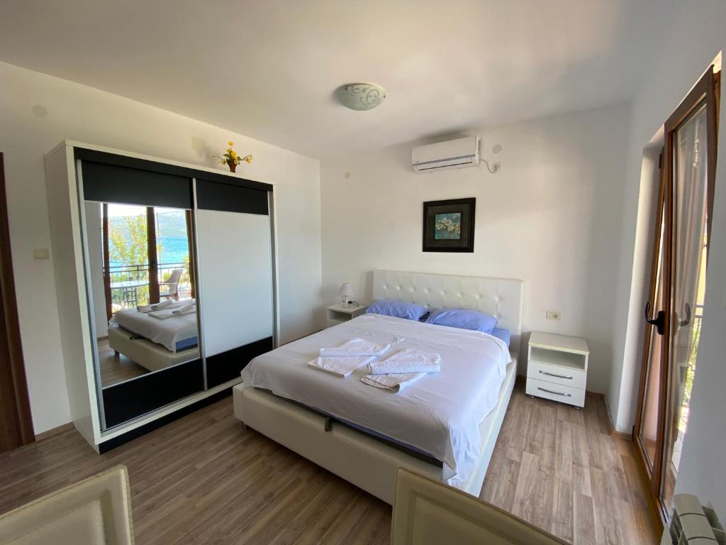 ein Schlafzimmer mit einem großen Bett und einem großen Spiegel in der Unterkunft Apartments Family in Tivat