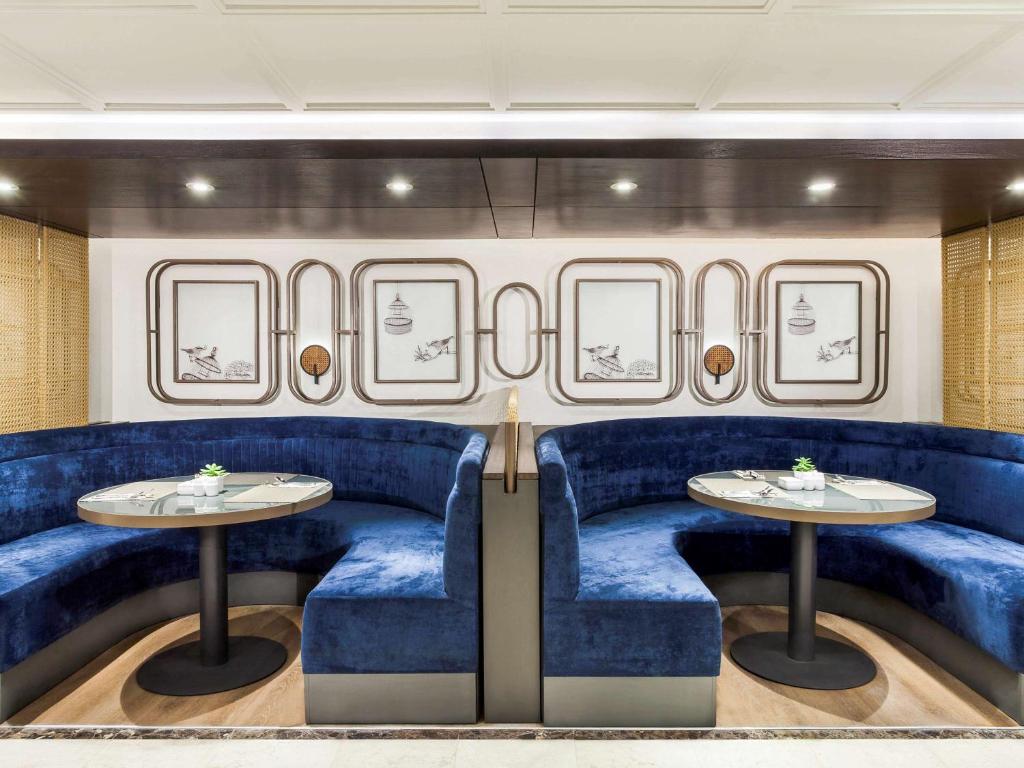 a dining room on a train with blue chairs and tables at Mercure Jakarta Batavia in Jakarta