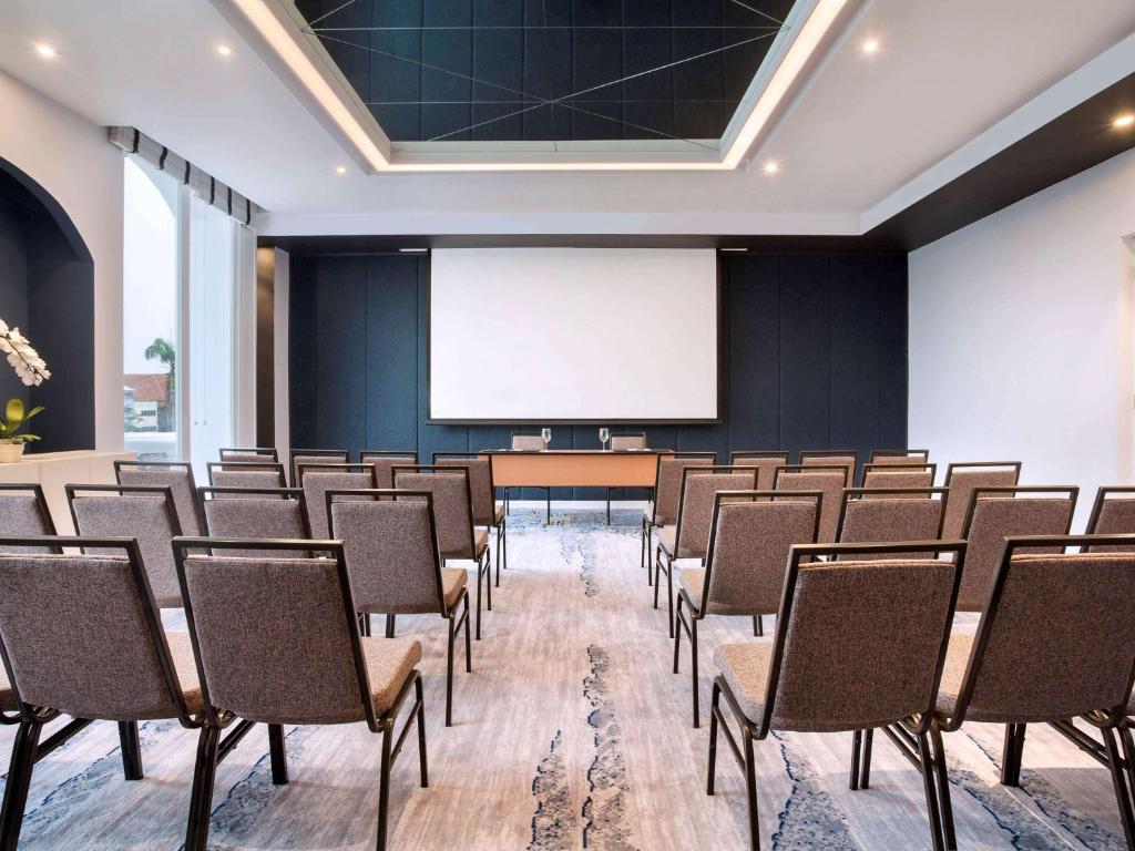 a lecture room with chairs and a white screen at Mercure Jakarta Batavia in Jakarta