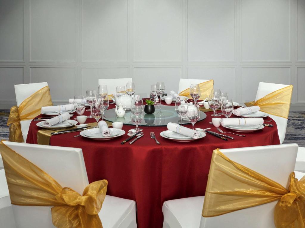 a table with a red table cloth and yellow bows at Mercure Jakarta Batavia in Jakarta