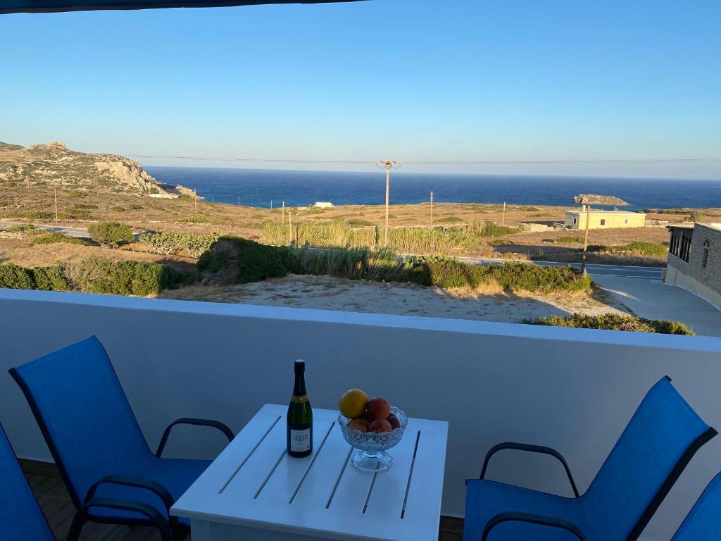 einen Tisch mit einer Flasche Wein und einer Schale Obst in der Unterkunft Michail Suites Afiartis Karpathos in Karpathos