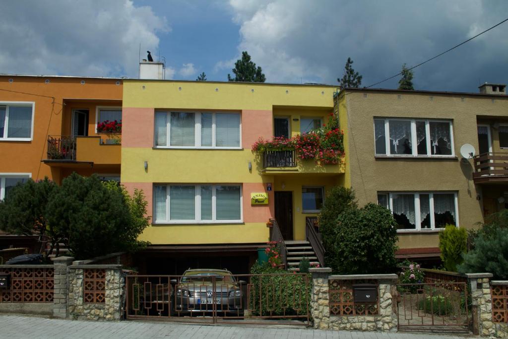 una casa gialla con una recinzione di fronte di Penzion Pavel a Karlovy Vary