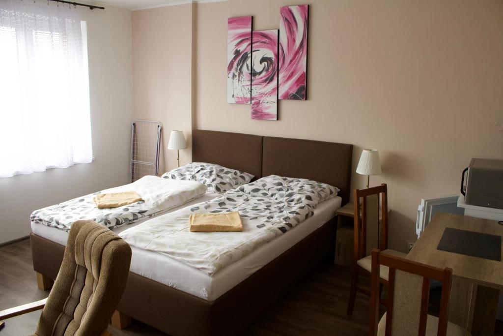 una camera da letto con un letto con due asciugamani sopra di Penzion Pavel a Karlovy Vary
