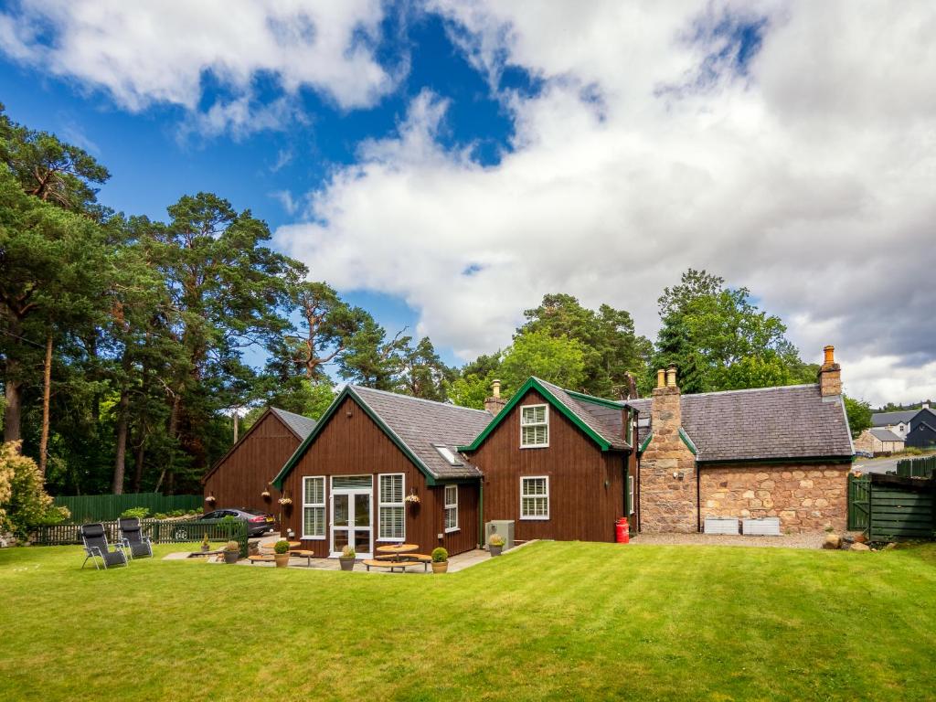 een huis met een gazon ervoor bij Coylumbridge Cottage in Aviemore