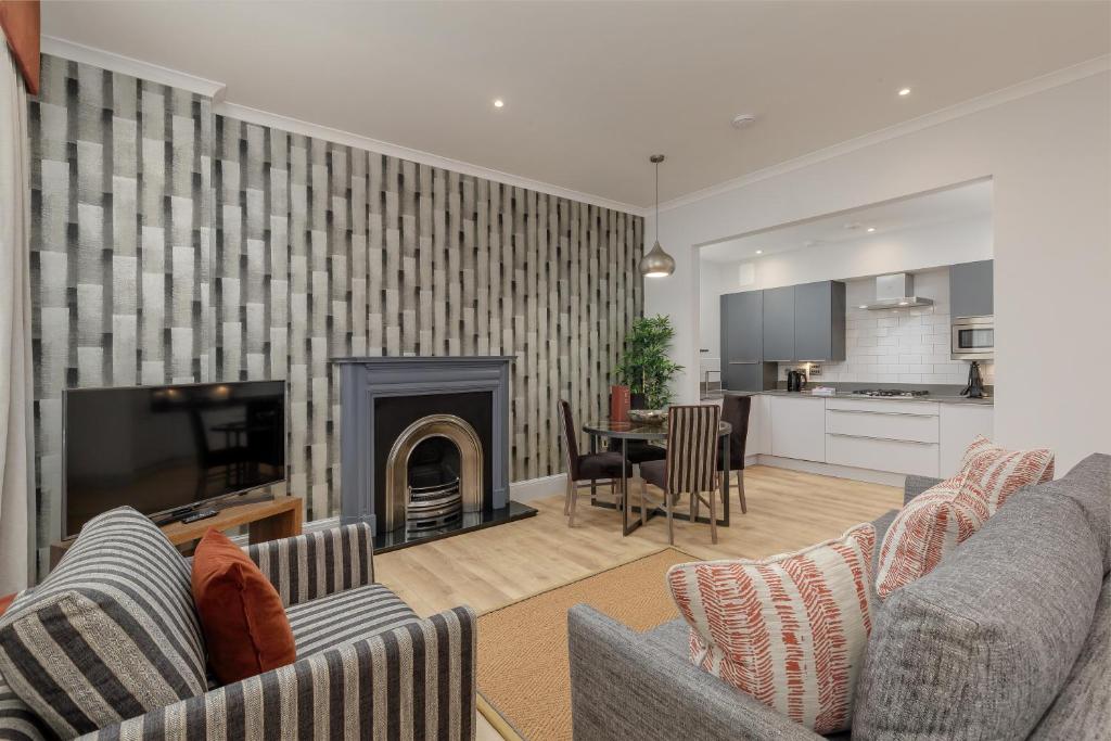 sala de estar con 2 sofás y chimenea en Destiny Scotland - Princes Street Residence, en Edimburgo