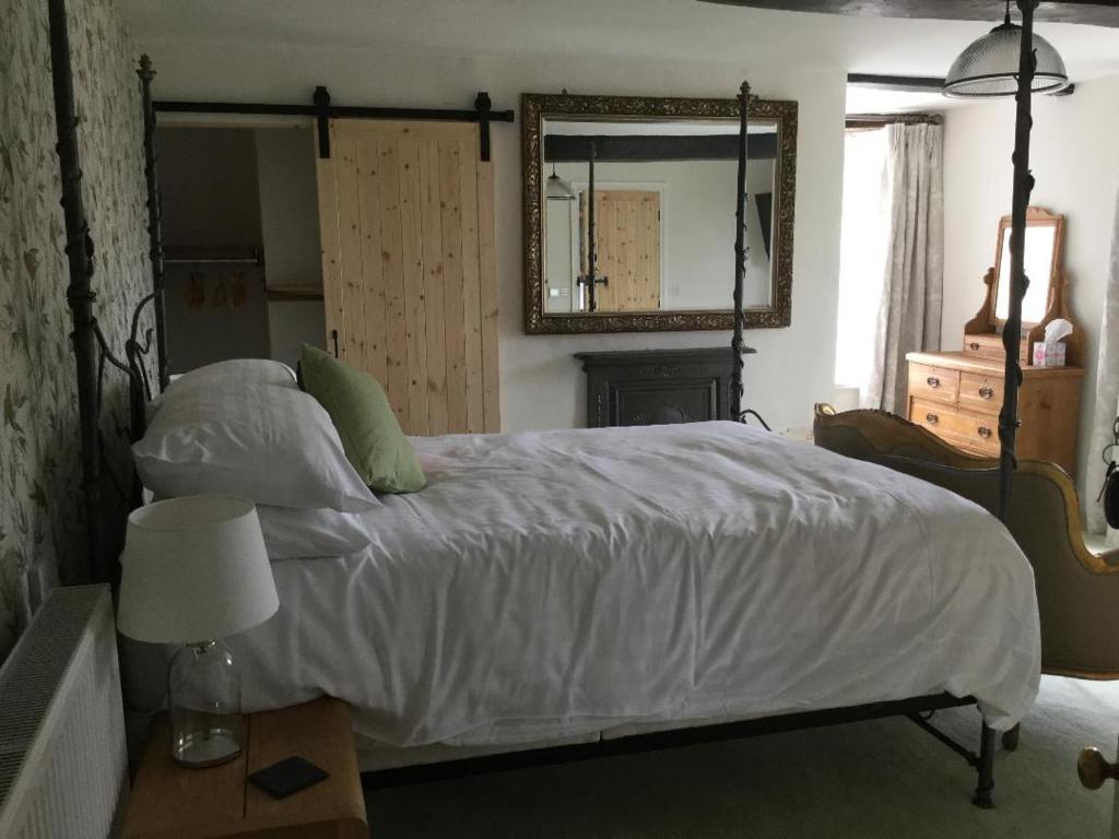 a bedroom with a large white bed with a mirror at The Burrows Bed and Breakfast in Pembroke
