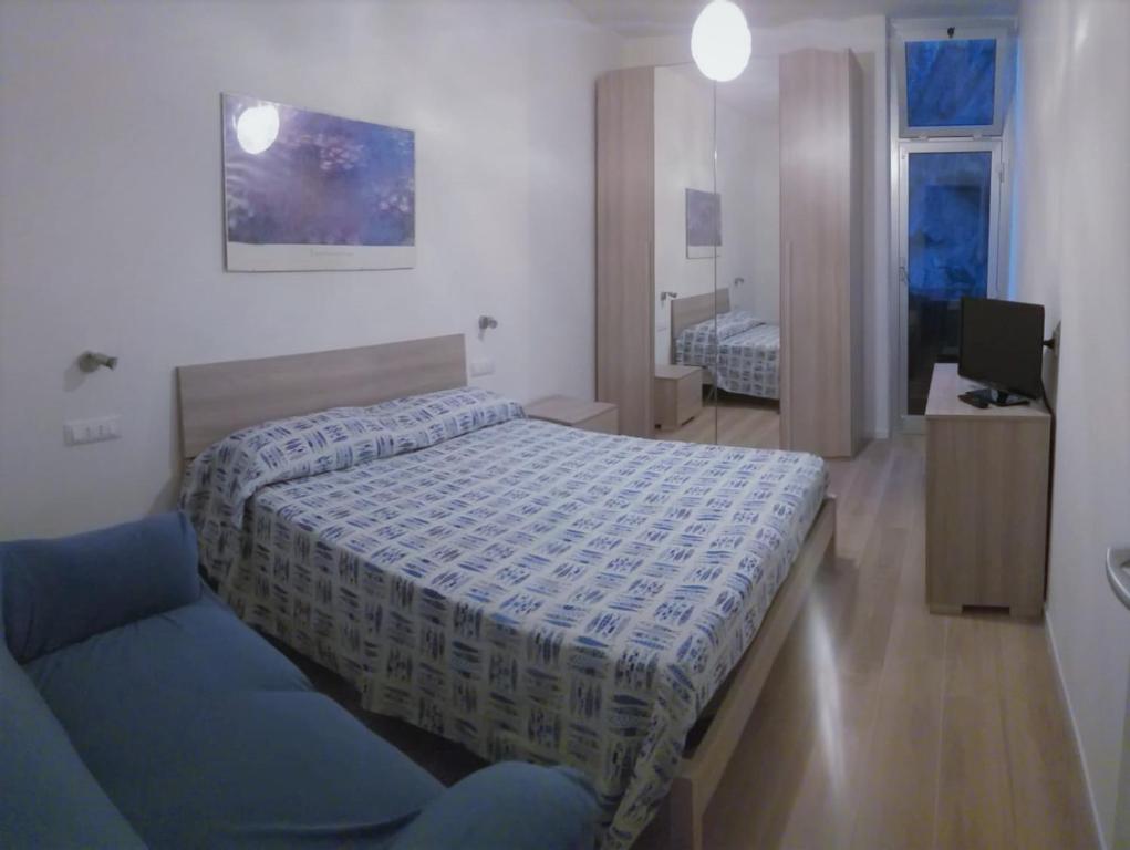 1 dormitorio con cama, sofá y TV en Rocce sul Mare, en Deiva Marina