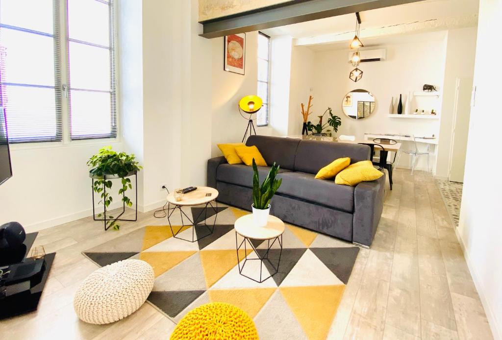 uma sala de estar com um sofá e uma mesa em Feel@Home Nemausus « Le 4 » em Nîmes