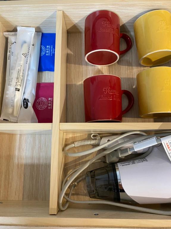 a cupboard filled with cups and mugs at IF Guest House in Tainan