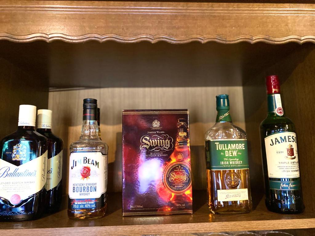 a group of bottles of alcohol sitting on a shelf at Hotel Auerhahn in Grevenkrug