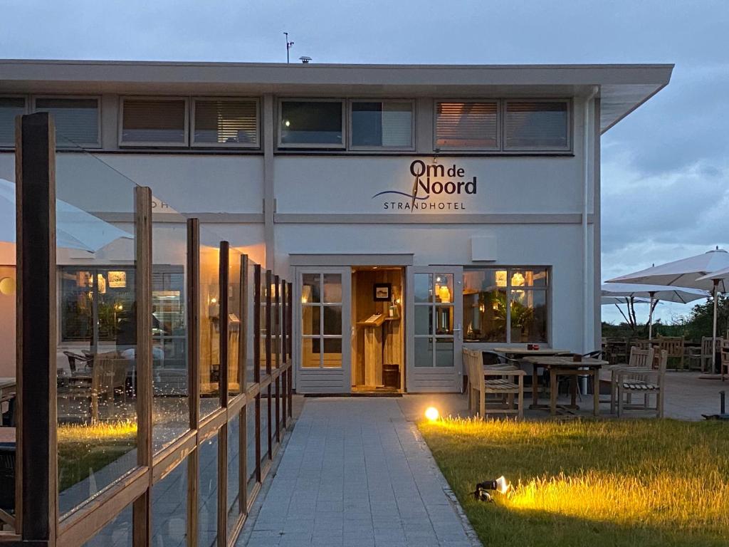 un bâtiment avec un panneau indiquant un restaurant d'ambiance en ligne dans l'établissement Strandhotel Om de Noord, à Schiermonnikoog