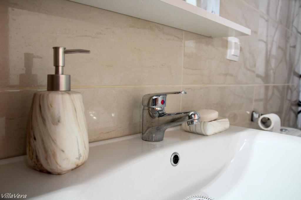 a bathroom sink with a soap dispenser on it at Luxury Apartment in Nikiti
