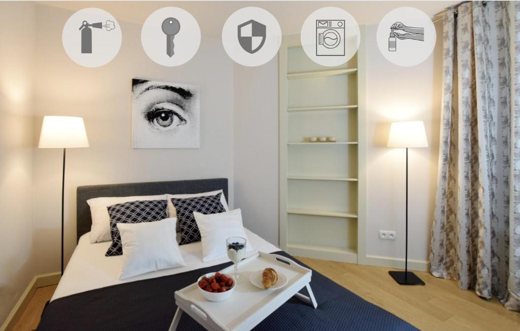 a bedroom with a bed and a table with food on it at Piłsudskiego In City Apartments in Krakow