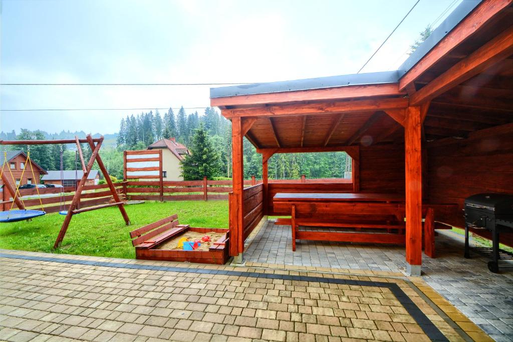 a playground with a bench and a swing at SŁONECZNE DOMKI in Istebna