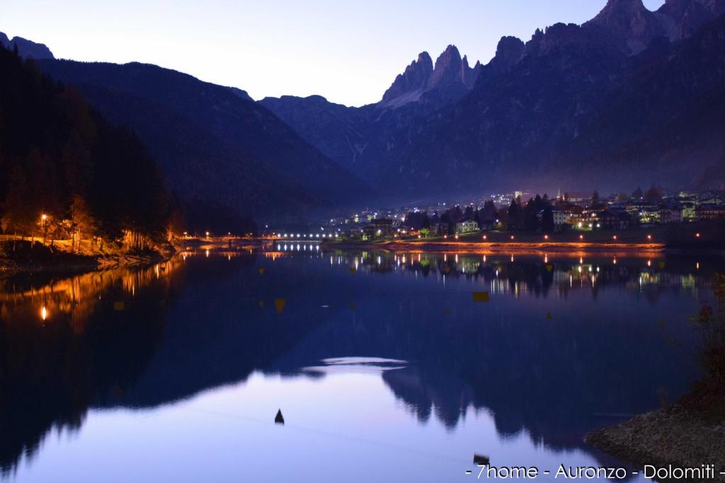 une grande étendue d'eau avec une ville et des montagnes dans l'établissement 7home, à Auronzo di Cadore