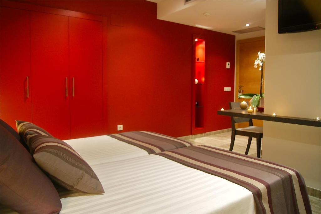 a bedroom with red cabinets and a bed and a desk at Restaurante y Alojamiento Can Mach in Tapis