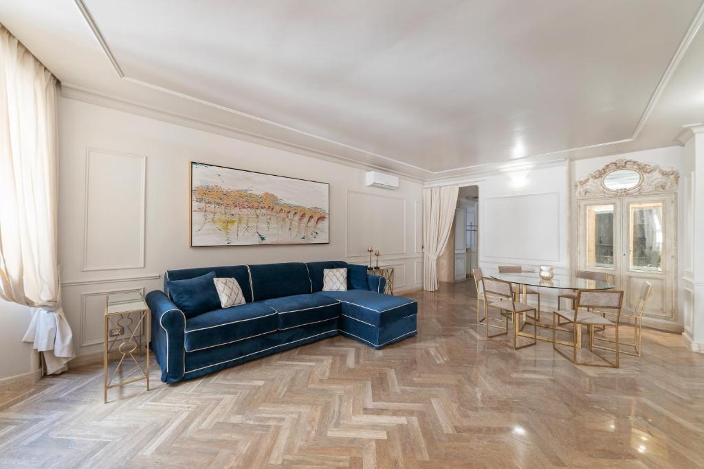 a living room with a blue couch and a table at BMGA l ViaPaola43 Palace in Rome