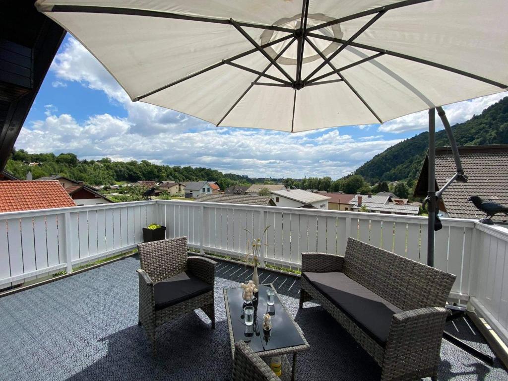 un patio con sombrilla, 2 sillas y una mesa en Apartment Kranj - huge terrace, free P, WI - FI, AC, en Kranj