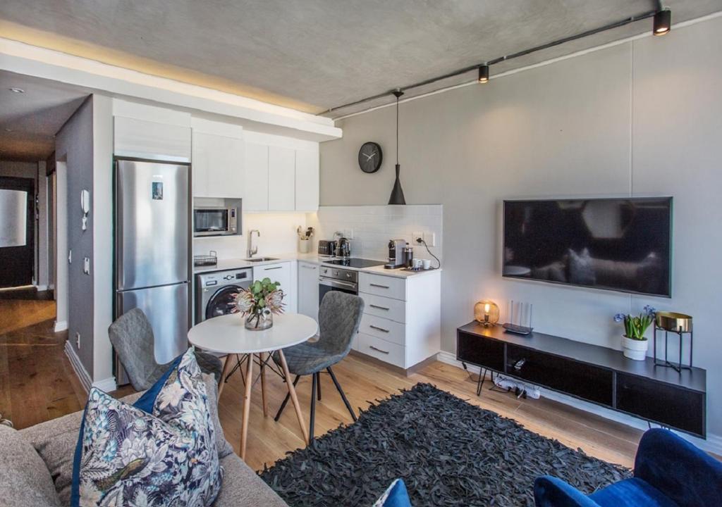 sala de estar con mesa y cocina en Docklands Deluxe One bedroom Apartments en Ciudad del Cabo