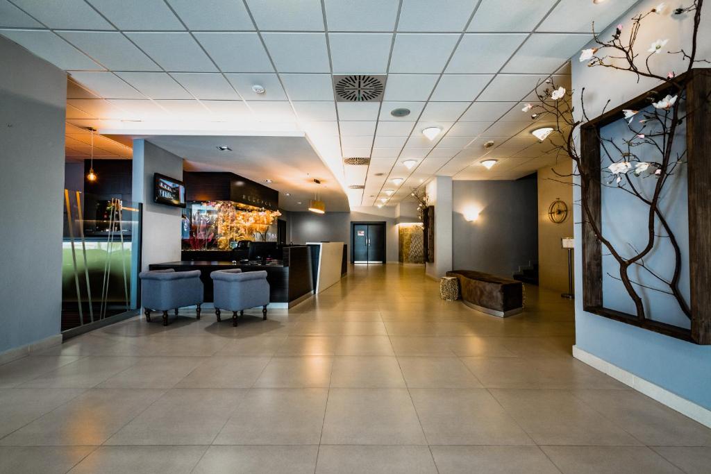 a lobby of a hotel with chairs and a bar at Hotel Palcát in Tábor