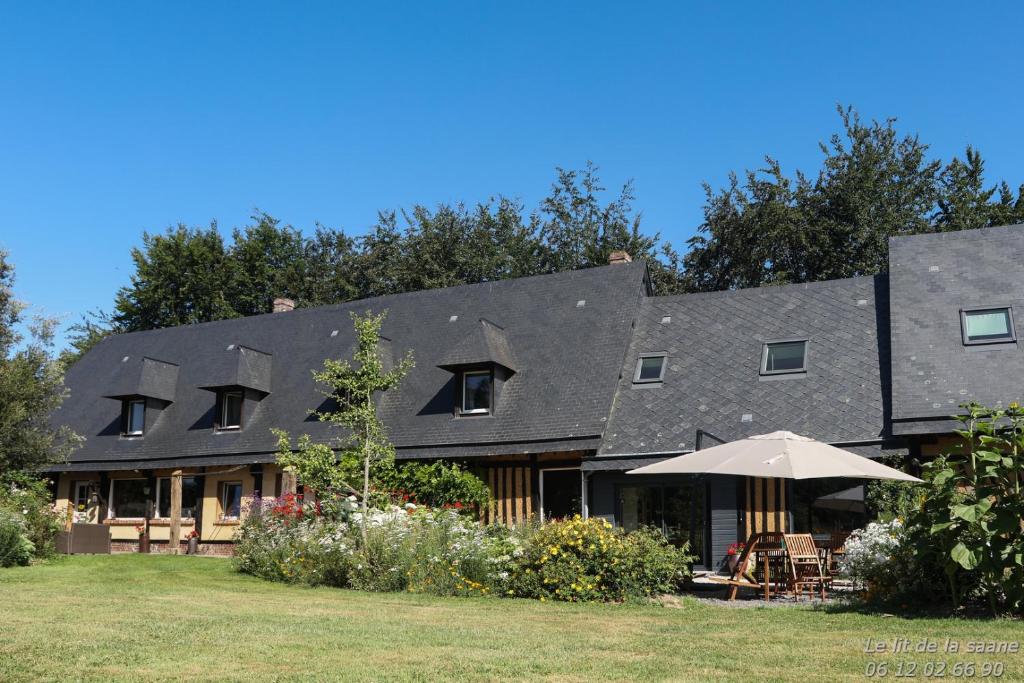 een huis met een zwart dak en een paraplu bij Le lit de la Saâne in Auzouville-sur-Saâne