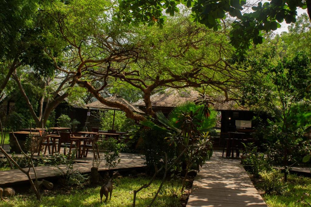 a patio with tables and chairs under a tree at Acacia Village in Juba