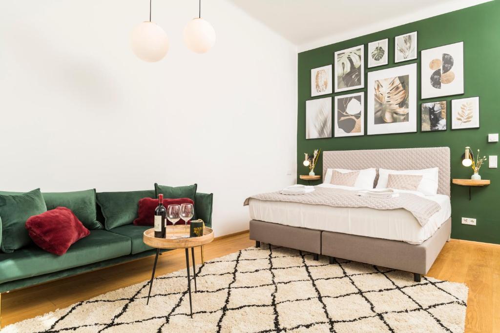 Mint@Naschmarkt Premium Apartments في فيينا: غرفة معيشة مع سرير واريكة خضراء