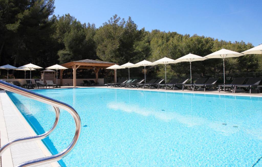 una gran piscina con sillas y sombrillas en Hapimag Apartments La Madrague, en La Madrague