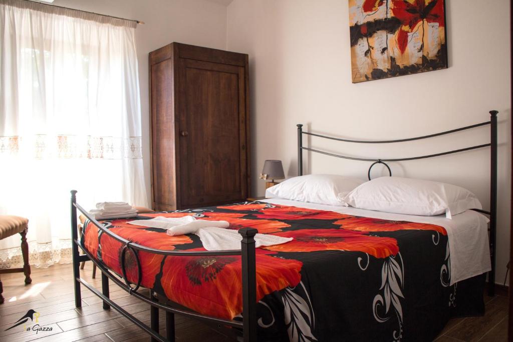 a bedroom with a bed with an orange and black blanket at La Gazza in Viterbo