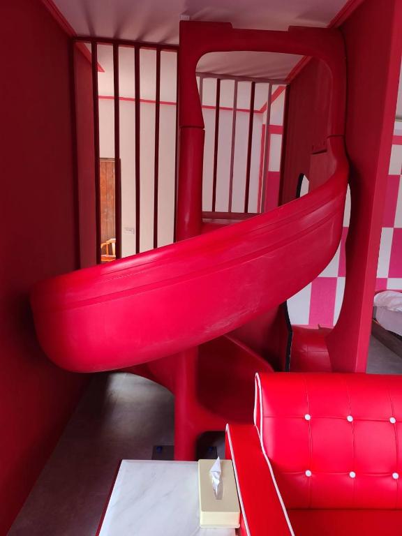 a red room with a red chair and a red couch at Julie&#39;s Garden, Cingjing - Fon Chin Homestay in Ren&#39;ai