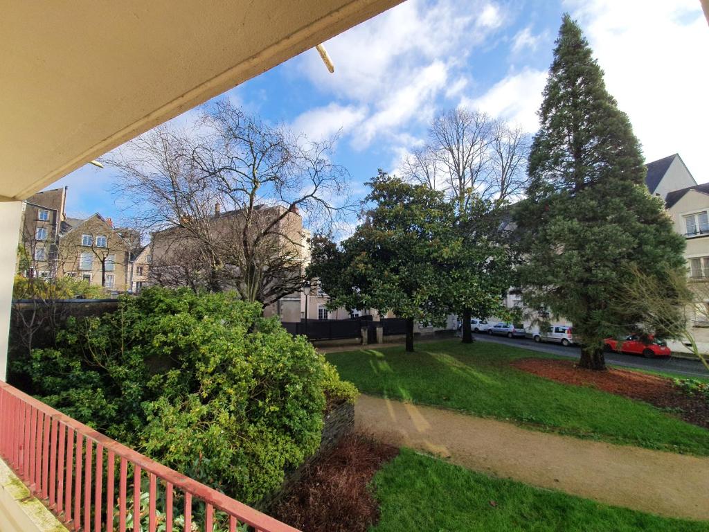 a balcony view of a yard with trees and houses at Les Petites Fontaines au cœur de la Doutre in Angers