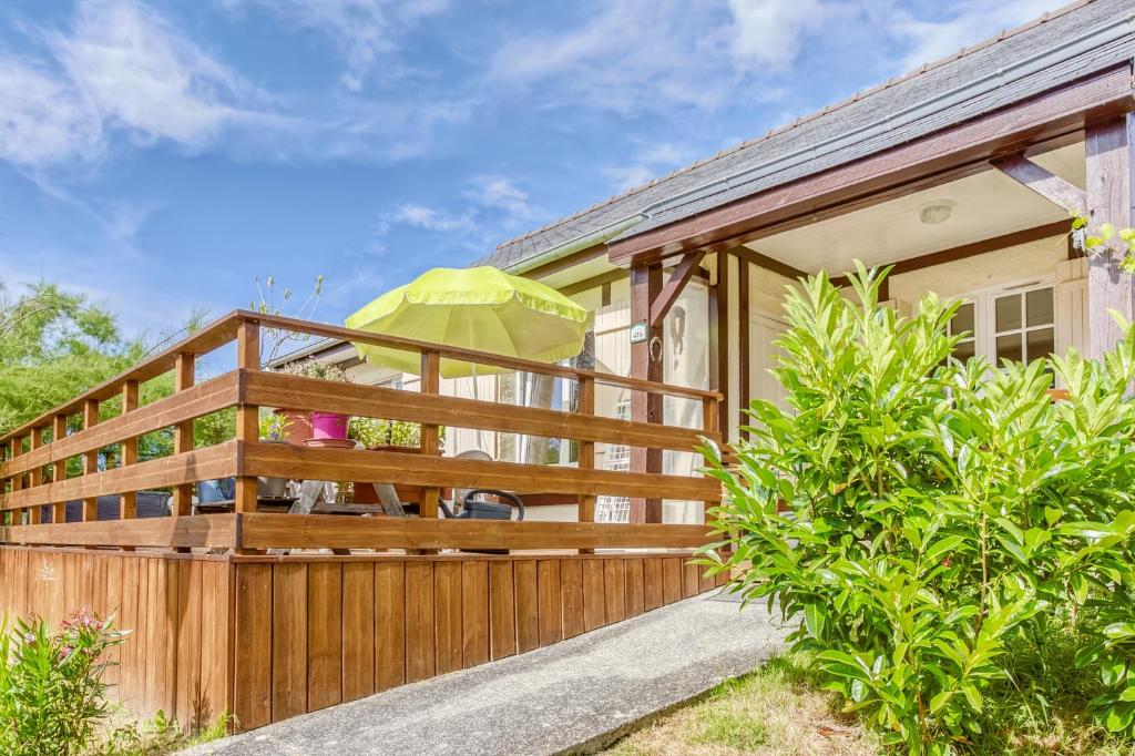 Casa con terraza de madera y valla en Le Vallon, en Branville