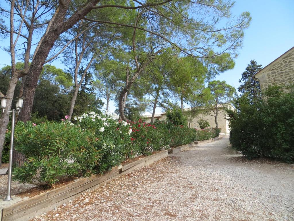 a garden with flowers and trees on a street at Les Studios-Hôtel de Sommières in Sommières
