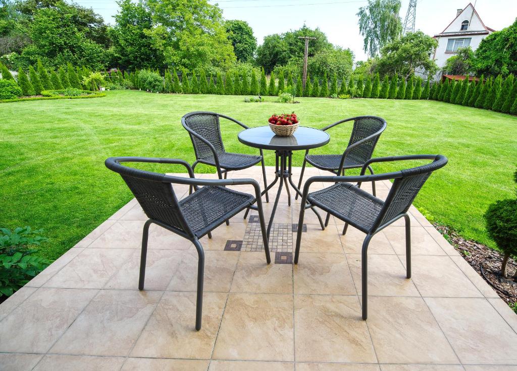 a patio table and four chairs on a patio at Happiness House Balcony & Nice Garden in Gdańsk