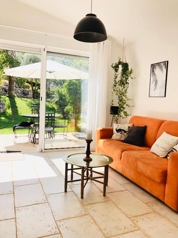 un salon avec un canapé orange et une table dans l'établissement Maison de vacances Villa Cardabella, à Le Tignet