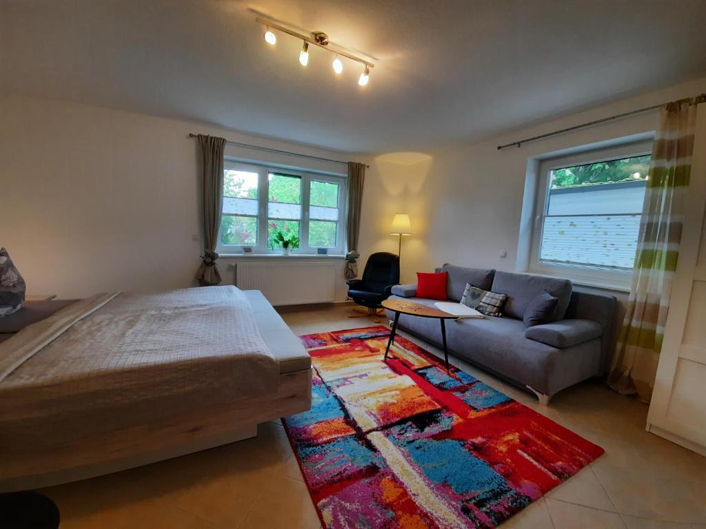 a bedroom with a bed and a couch and a rug at Ferienwohnungen Göhren in Göhren
