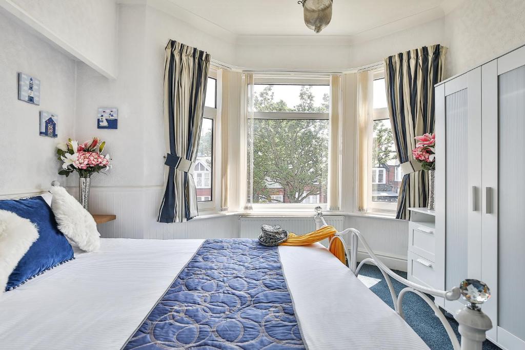 a bedroom with a bed and two windows at The Kensington in Scarborough