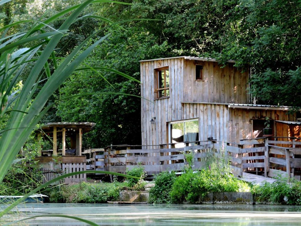 een houten gebouw naast een waterlichaam bij La Cabane in Connigis