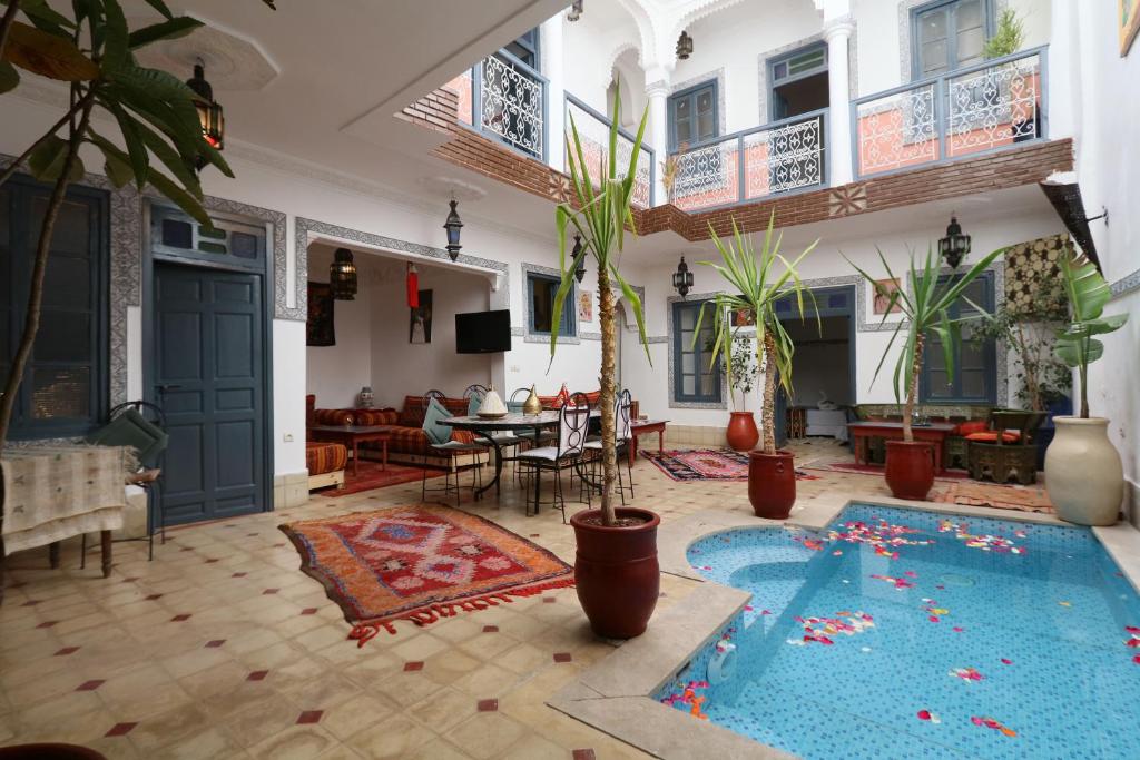 una gran sala de estar con una piscina en el centro en Riad Ibiza Star, en Marrakech