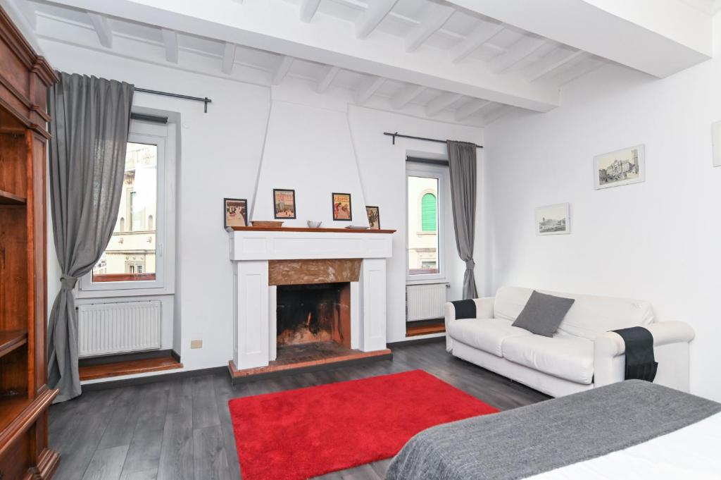 een witte woonkamer met een open haard en een witte bank bij Gorgeous Trastevere loft on the river in Rome