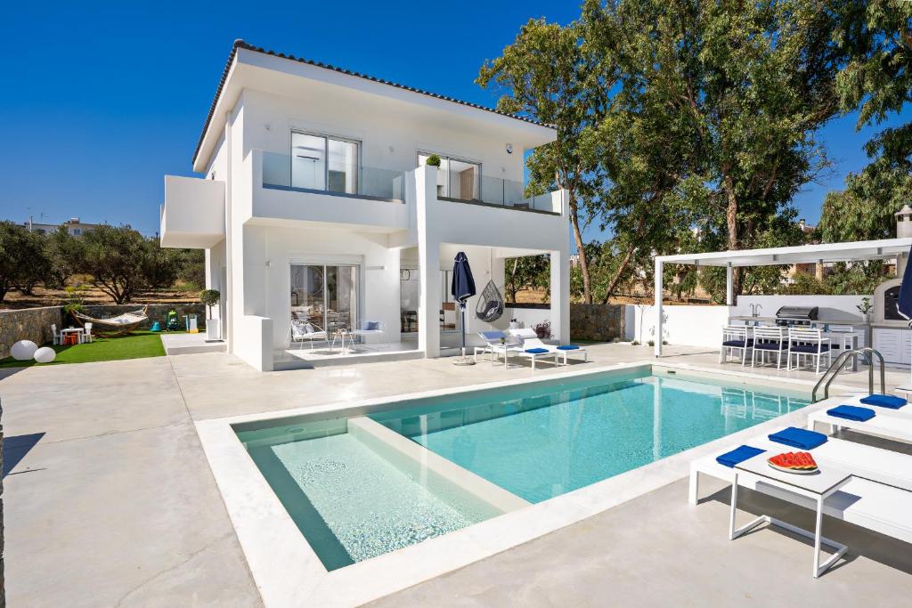 a villa with a swimming pool and a house at Constantinos Villa, Sublime Island Εscape, By ThinkVilla in Panormos Rethymno