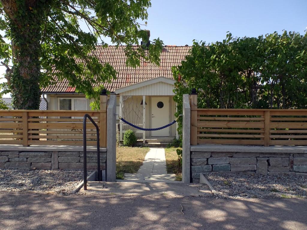 une maison dotée d'une clôture avec une corde bleue dans l'établissement 1B, Stuga m havsutsikt & 50m till strand, à Byxelkrok