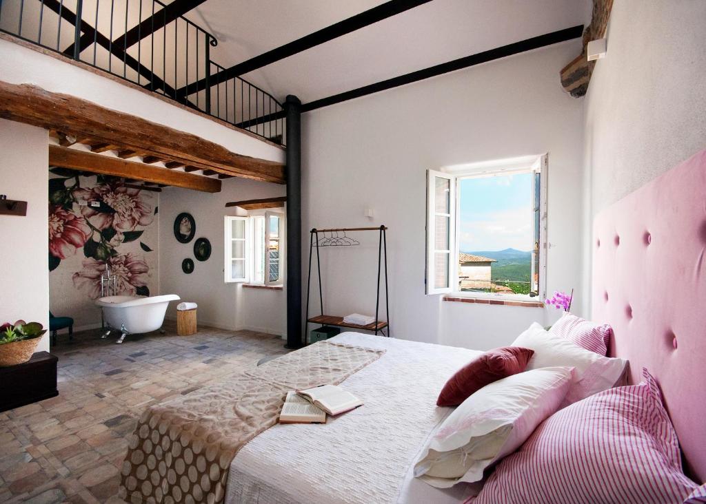 una camera con un grande letto e una vasca da bagno di Agriturismo La Via Dell'Oliviera a Ciciano