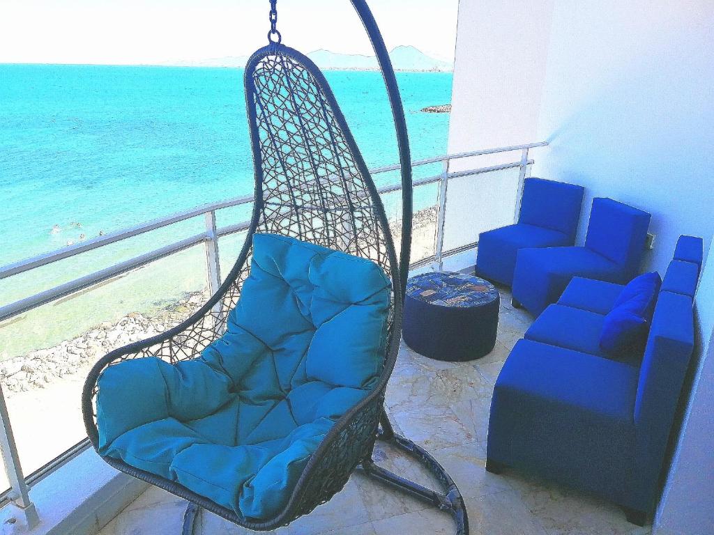 una silla mecedora en un balcón con vistas al océano en The bleu sea, en Túnez