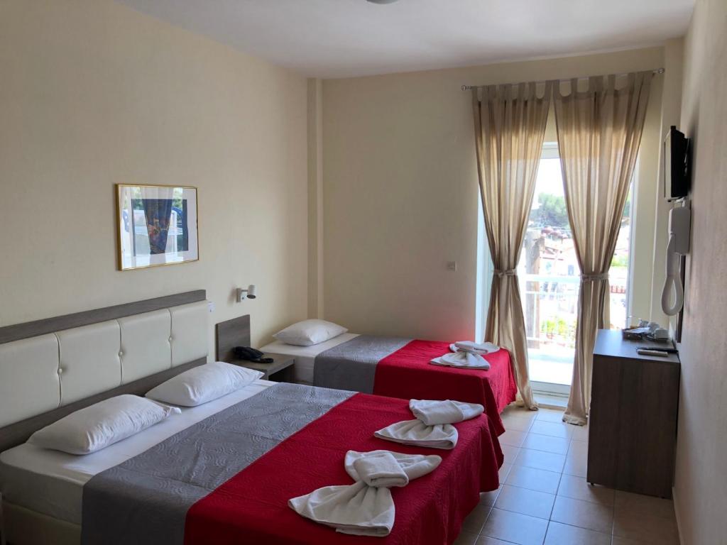 a hotel room with two beds and a window at SimOtel Ermis in Hanioti