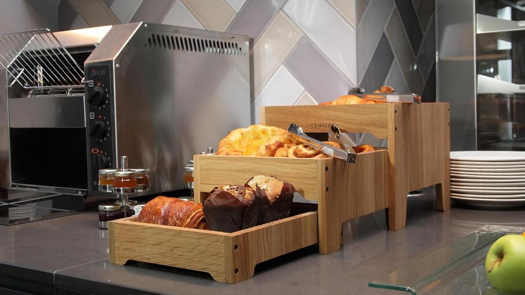 a kitchen with two wooden trays with different types of bread at Crowne Plaza Aberdeen Airport by IHG in Dyce