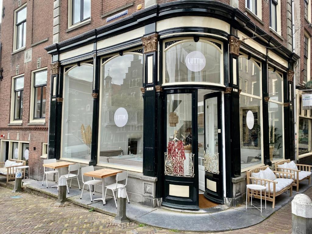 a store front with tables and chairs in a street at Luttik in Alkmaar
