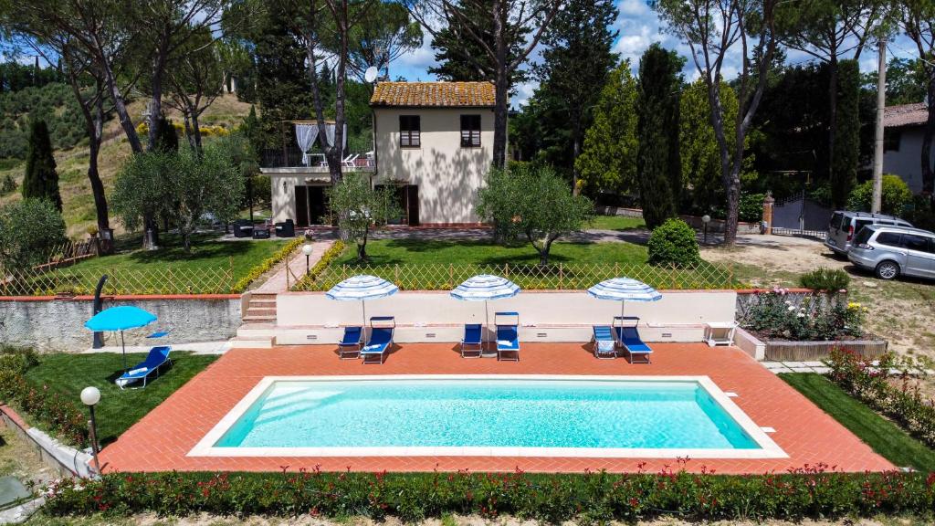 een zwembad met stoelen en parasols voor een huis bij Il Pucchio in Certaldo