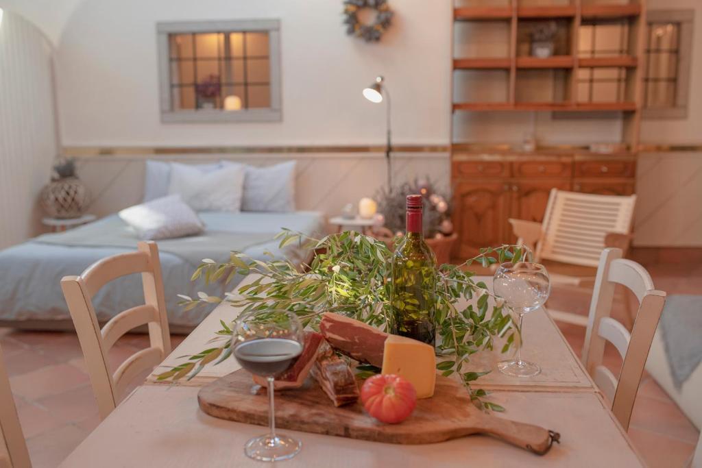 una mesa con un plato de comida y copas de vino en Apartment Ana - Karst Cycling Paradise en Dutovlje