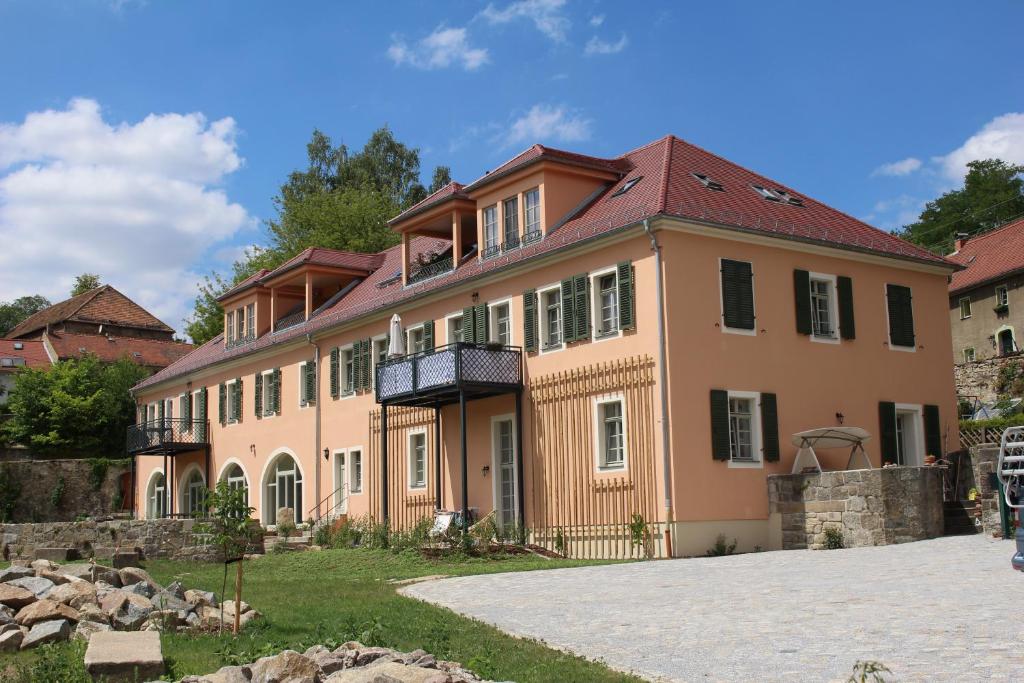 ein großes rosafarbenes Haus mit einem Dach in der Unterkunft Ferienwohnung Kapplermühle in Bautzen